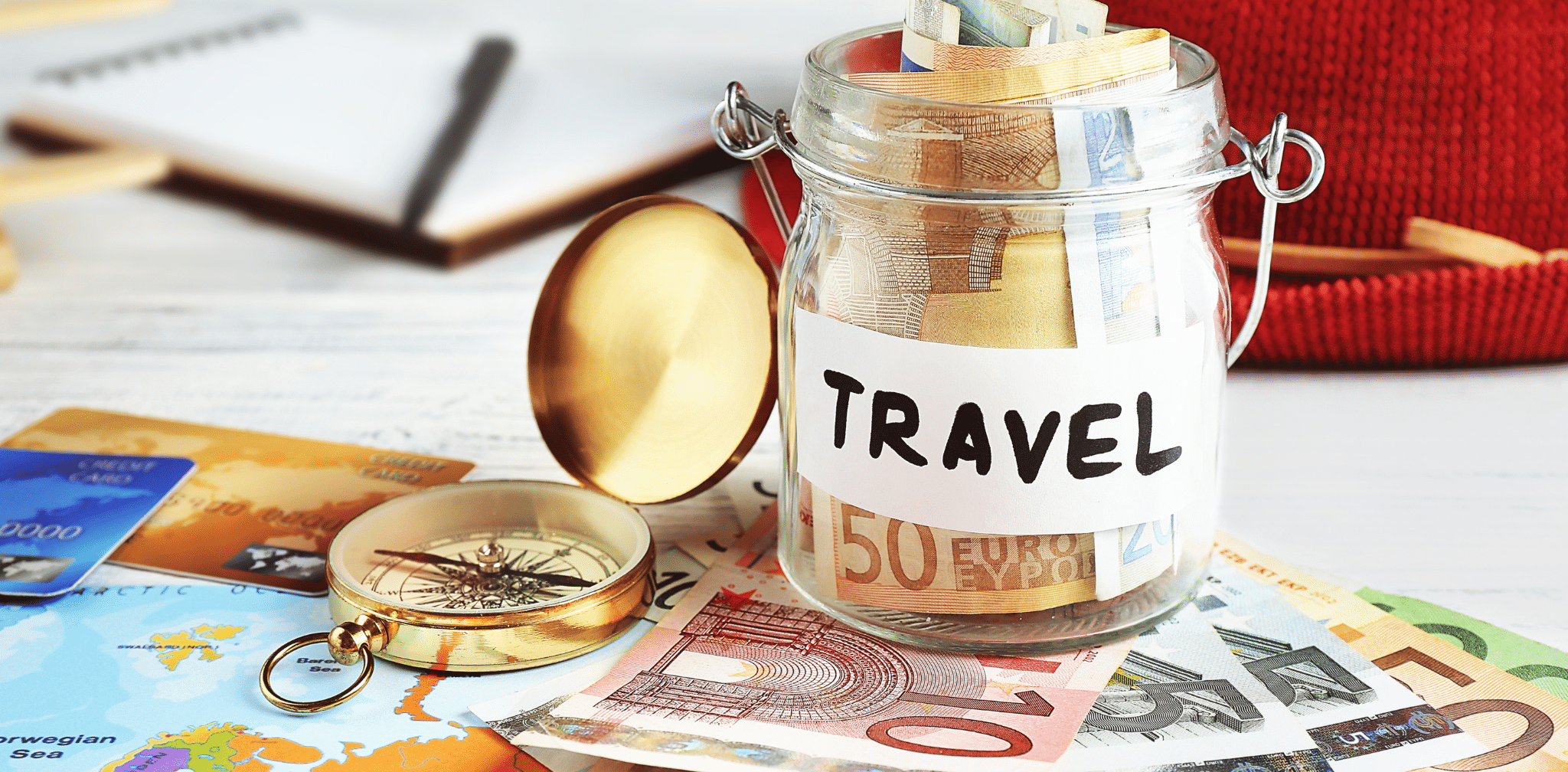 Pessoa planejando viagem internacional com passaporte, cartão e celular, ao lado de notas de dólar